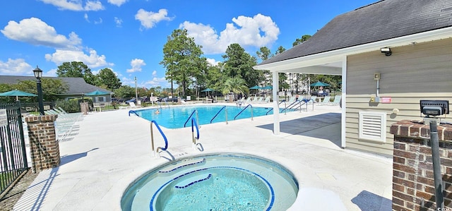 community pool featuring a community hot tub, fence, and a patio