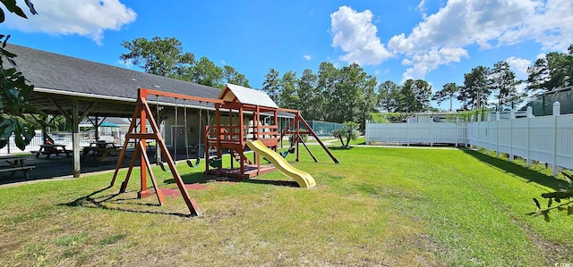 community jungle gym featuring fence and a yard