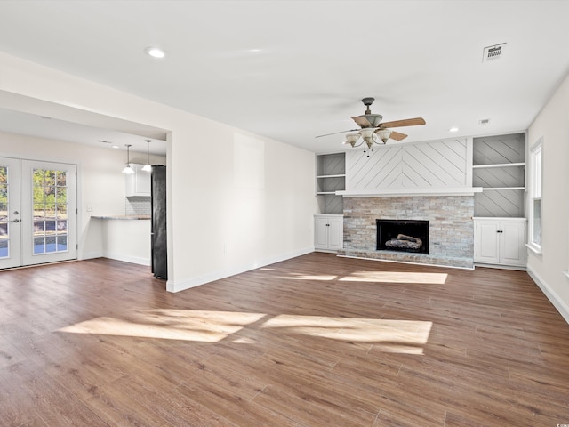 unfurnished living room with french doors, ceiling fan, dark wood-type flooring, and built in features