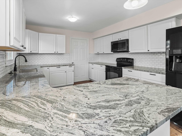 kitchen with hardwood / wood-style flooring, black appliances, decorative backsplash, and white cabinets