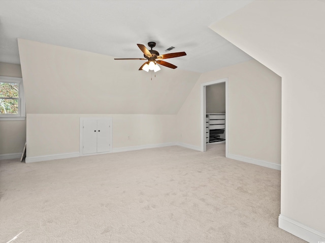 additional living space with ceiling fan, lofted ceiling, and light carpet