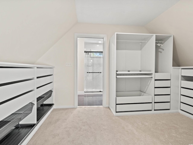 spacious closet featuring vaulted ceiling and light colored carpet