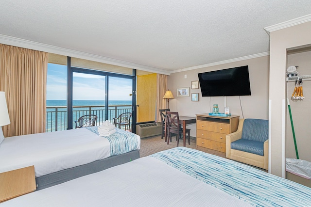 6900 N Ocean Blvd Unit 812, Myrtle Beach, SC 29572 - bedroom featuring access to outside, ornamental molding, a textured ceiling, a wall unit AC, and a wall of windows