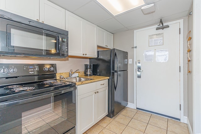 6900 N Ocean Blvd Unit 812, Myrtle Beach, SC 29572 - kitchen featuring black appliances, light tile patterned floors, white cabinetry, a drop ceiling, and light countertops