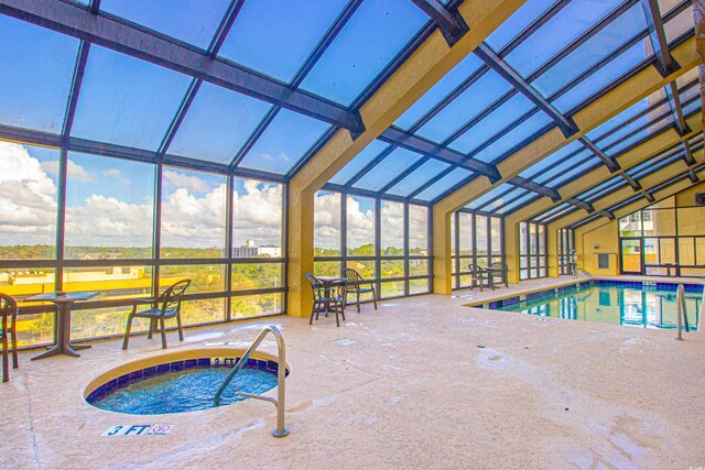 view of swimming pool with a patio area and an indoor hot tub