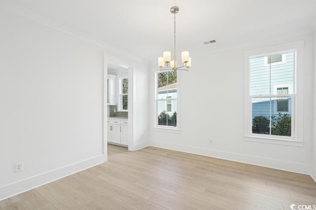 unfurnished room with visible vents, baseboards, light wood-style floors, and an inviting chandelier