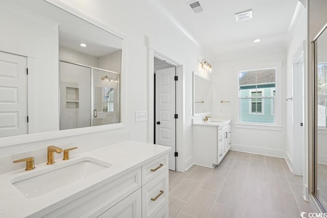 bathroom featuring a sink, visible vents, two vanities, and a shower stall