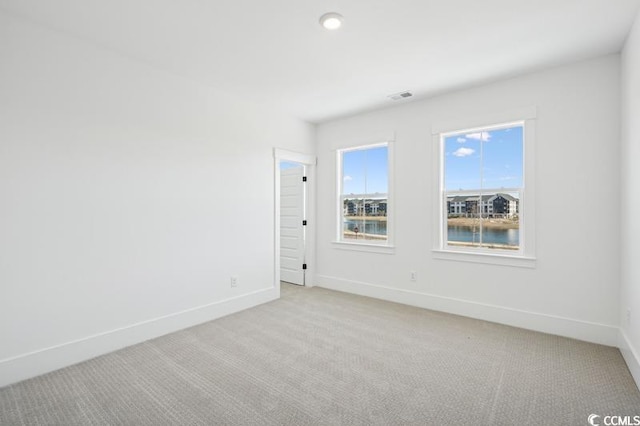 carpeted spare room with a water view