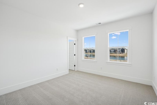 empty room with recessed lighting, visible vents, baseboards, and light carpet