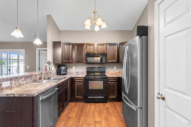 kitchen with light hardwood / wood-style flooring, a chandelier, sink, black appliances, and pendant lighting