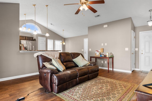 living room with ceiling fan with notable chandelier, vaulted ceiling, and hardwood / wood-style flooring