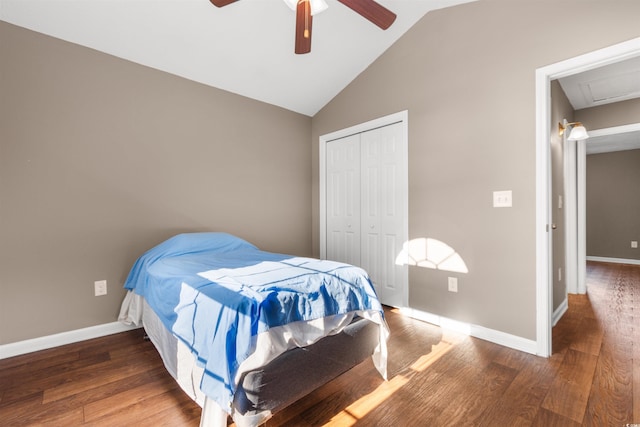 bedroom featuring dark wood-type flooring, lofted ceiling, ceiling fan, and a closet