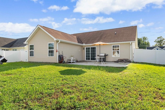 rear view of property with a lawn and a patio