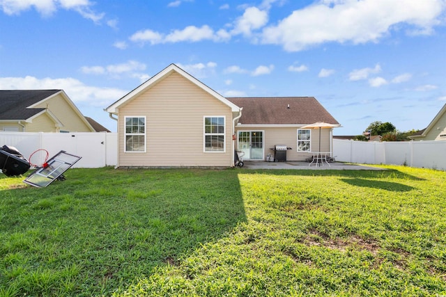 rear view of house with a yard and a patio area