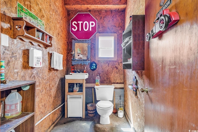 bathroom with sink, concrete floors, and toilet