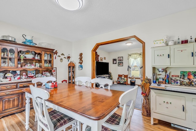 3747 Bakers Chapel Rd, Aynor, SC 29511 - dining room with light wood finished floors, arched walkways, and a textured ceiling