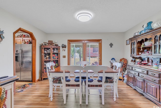 dining room featuring a textured ceiling and light hardwood / wood-style floors