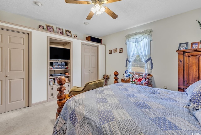 bedroom with ceiling fan, light carpet, and a textured ceiling