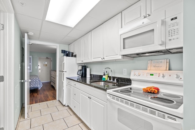 kitchen with sink, white cabinetry, a drop ceiling, white appliances, and light tile patterned floors