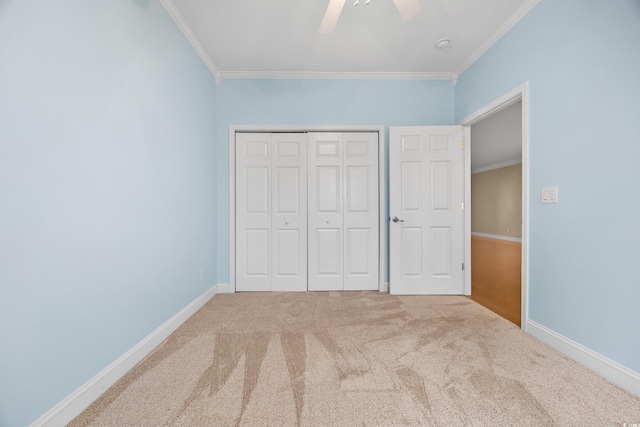 unfurnished bedroom with crown molding, carpet flooring, ceiling fan, and a closet