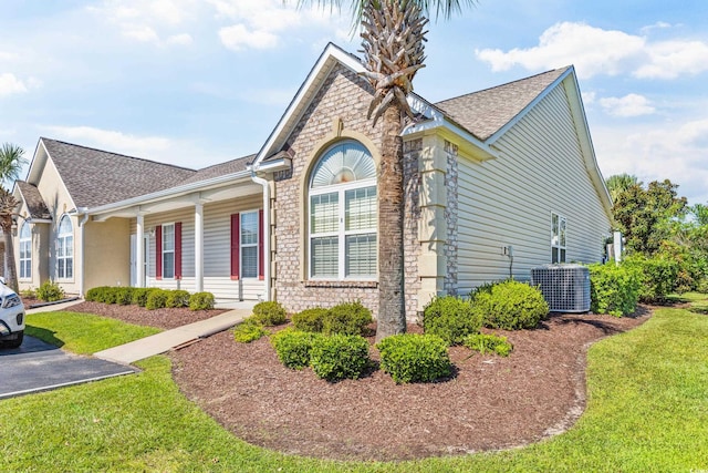 view of front of property featuring central air condition unit and a front yard