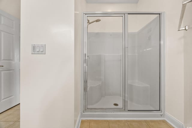 bathroom featuring a shower with door and tile patterned flooring