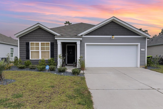 view of front of home featuring a garage and a lawn