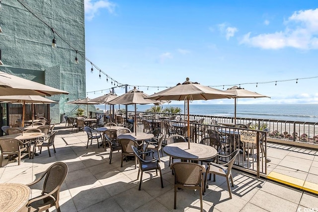 view of patio / terrace with a view of the beach and a water view