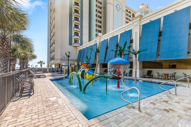 view of swimming pool featuring pool water feature and a patio