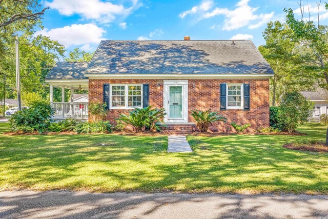 view of front of house featuring covered porch and a front yard