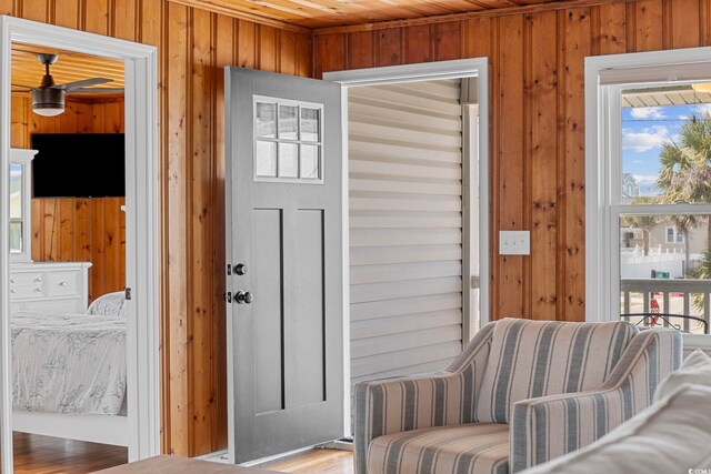 entryway featuring wood ceiling, a wealth of natural light, wooden walls, and hardwood / wood-style floors