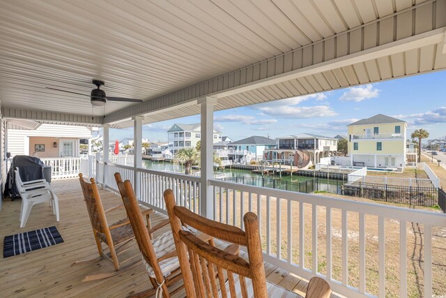 wooden terrace featuring a water view and ceiling fan