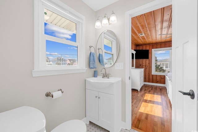 bathroom with vanity, toilet, wood ceiling, and plenty of natural light