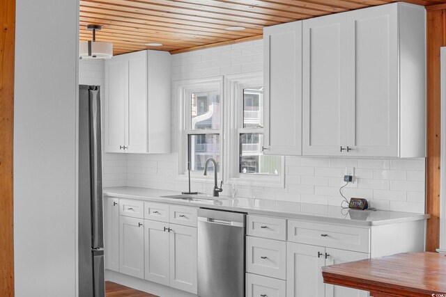 kitchen featuring sink, white cabinetry, hanging light fixtures, and stainless steel appliances