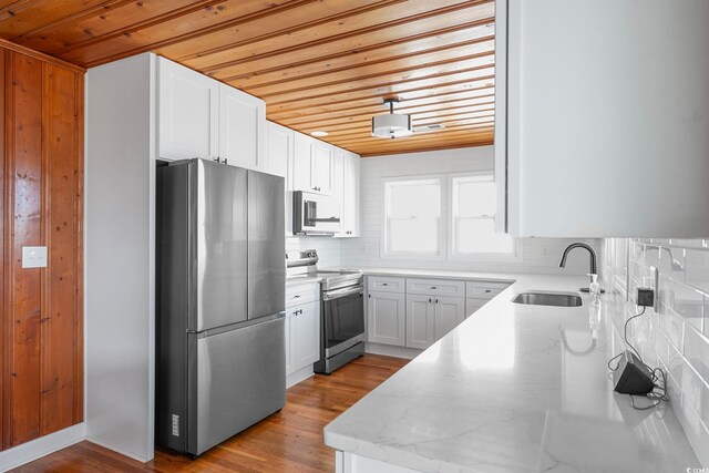 kitchen featuring light hardwood / wood-style floors, white cabinetry, tasteful backsplash, and stainless steel appliances