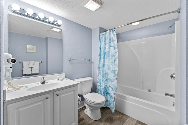 full bathroom with wood-type flooring, a textured ceiling, shower / tub combo with curtain, vanity, and toilet