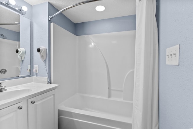 bathroom featuring a textured ceiling, vanity, and shower / bath combo with shower curtain