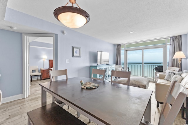 dining area with light hardwood / wood-style floors and a textured ceiling