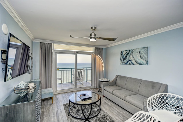 living room with a water view, ceiling fan, crown molding, and wood-type flooring