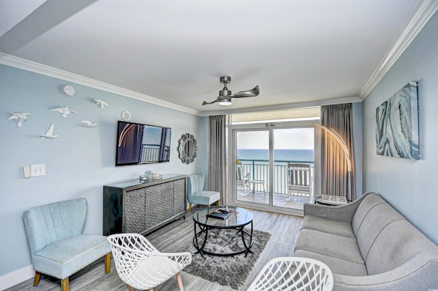 living room with light wood-type flooring, crown molding, a water view, and ceiling fan