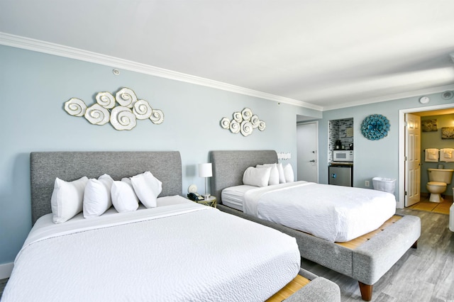 bedroom featuring hardwood / wood-style flooring, crown molding, and ensuite bath