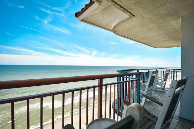 balcony featuring a beach view and a water view