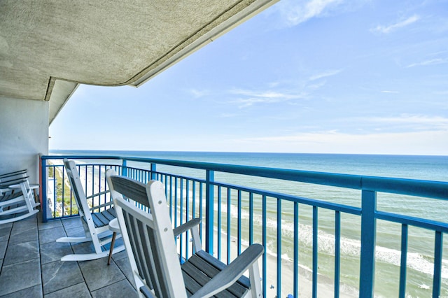 balcony featuring a view of the beach and a water view