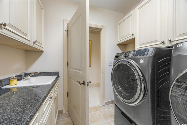 laundry area featuring washer and clothes dryer, light tile patterned floors, cabinets, and sink