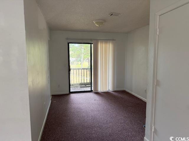 empty room featuring baseboards, carpet floors, and a textured ceiling