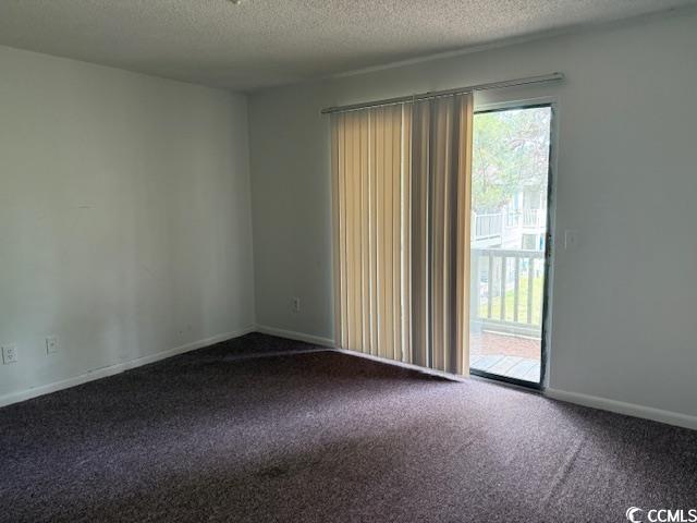 carpeted spare room with a textured ceiling and baseboards