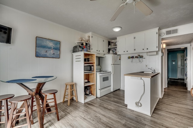 kitchen with open shelves, visible vents, light wood finished floors, white appliances, and a ceiling fan