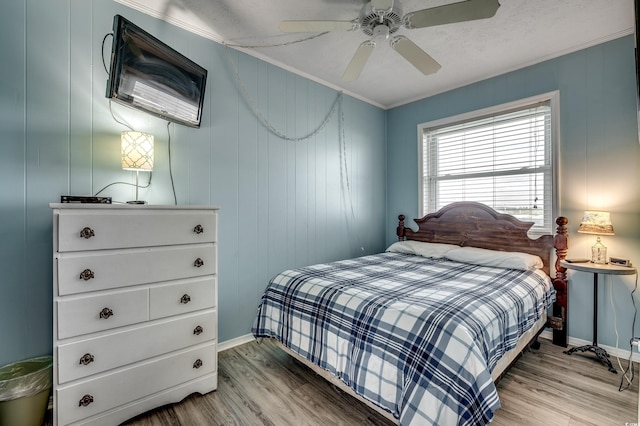 bedroom featuring crown molding, baseboards, and light wood-style floors