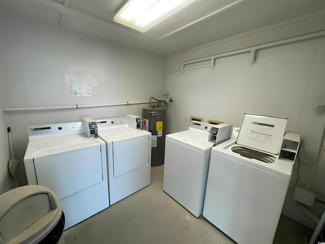 washroom with washing machine and dryer and water heater