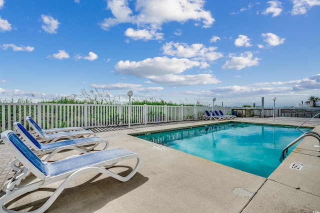 pool featuring fence and a patio area